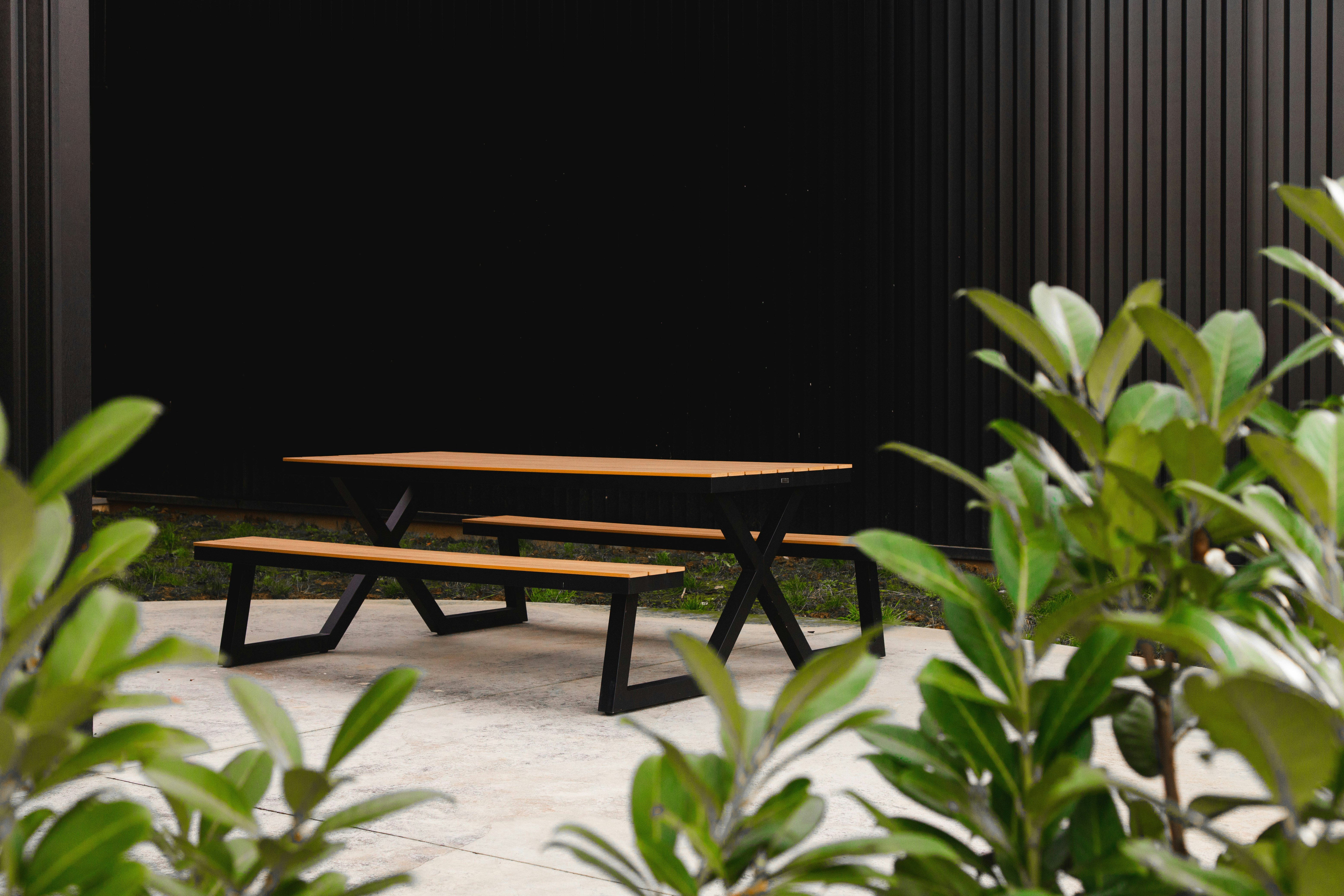 brown wooden bench beside green plant